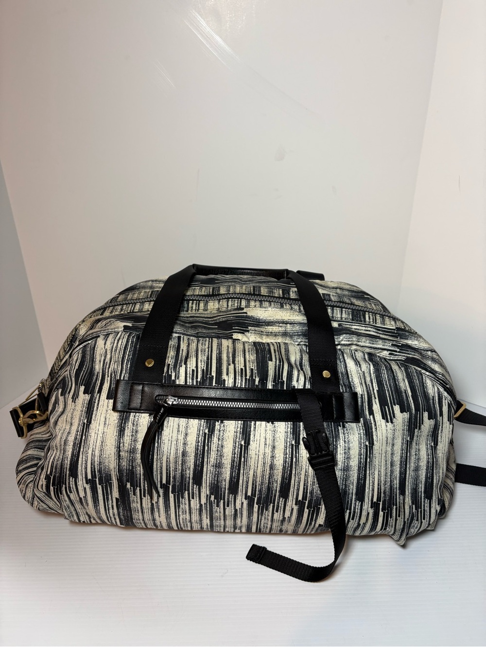Lululemon All You Need duffel bag features a black and cream with gold hardware